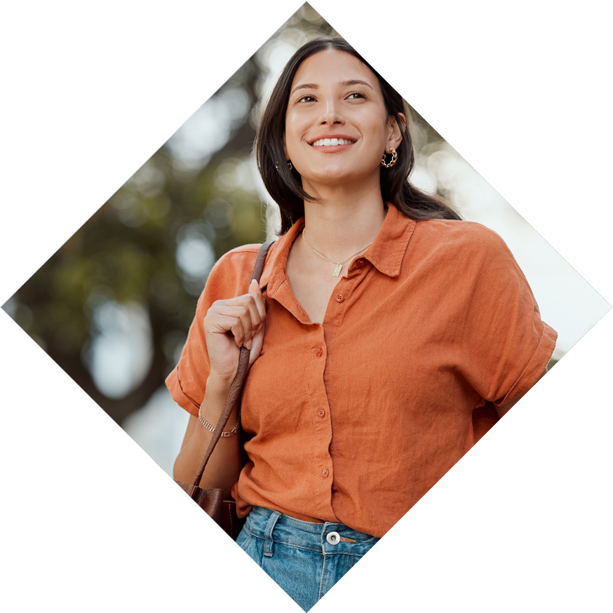 Woman in orange shirt smiling holding a work bag